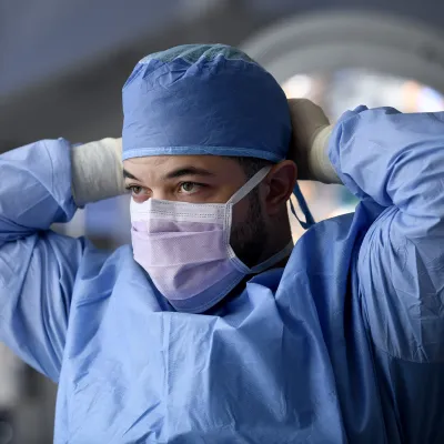Surgeon putting on a face mask