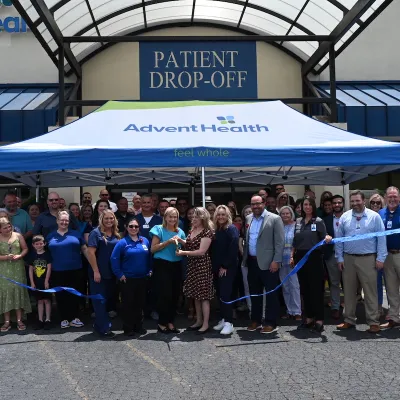 a group gathers to cut the ribbon to celebrate cedartown clinic opening