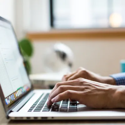 Fingers typing on a laptop