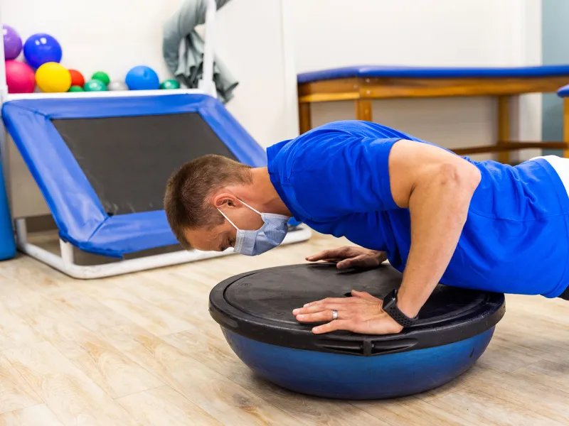 A man on a medicine ball balancer