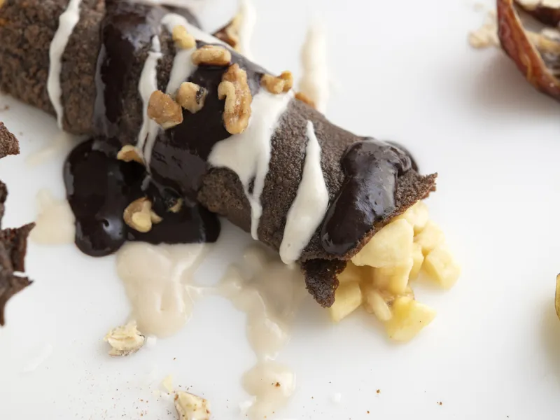 Chocolate crepe with banana filling on white surface