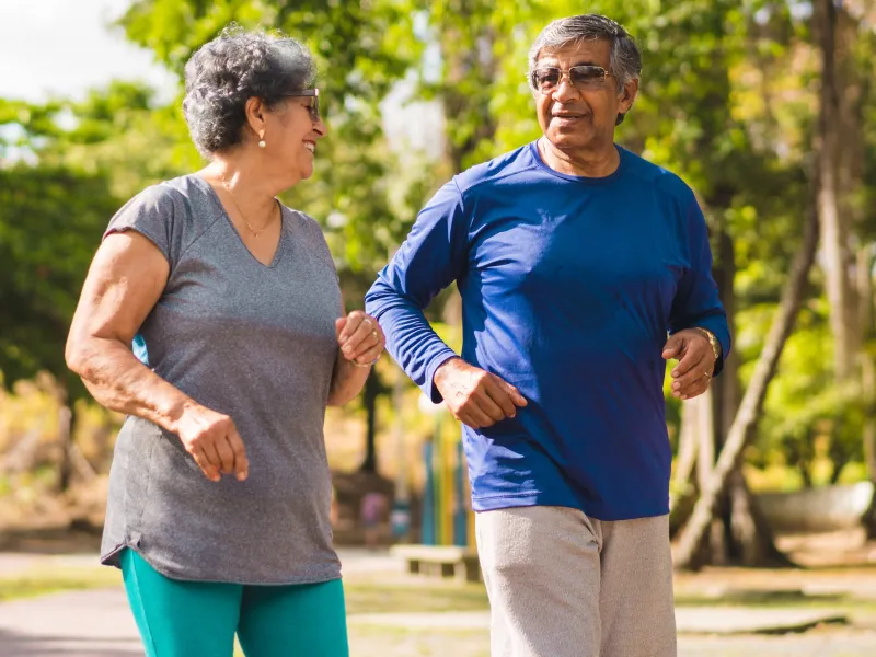 A mature couple exercising outdoors together.