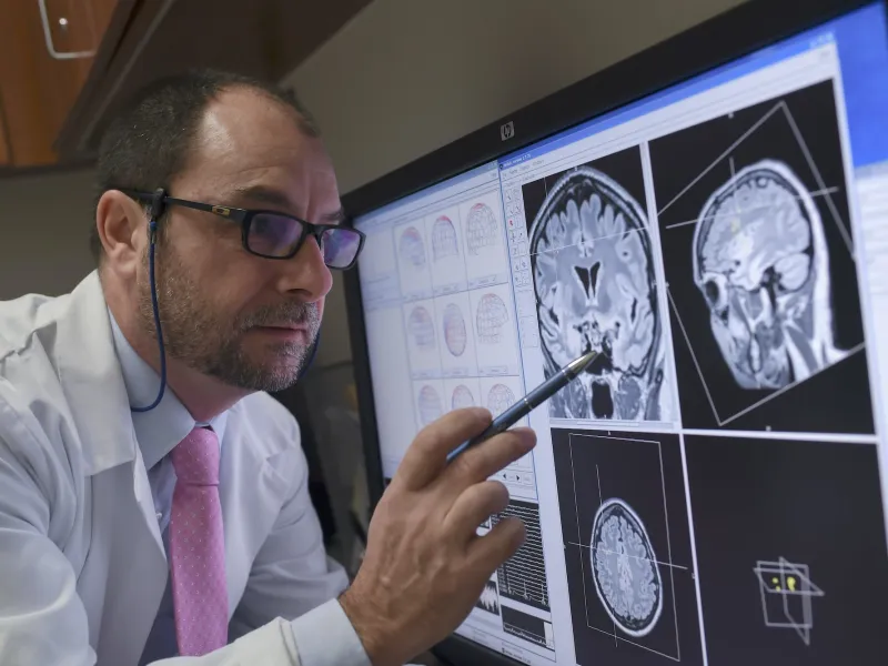 A physician reviewing MEG images on a computer monitor