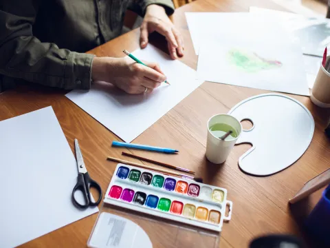 Person drawing with art supplies