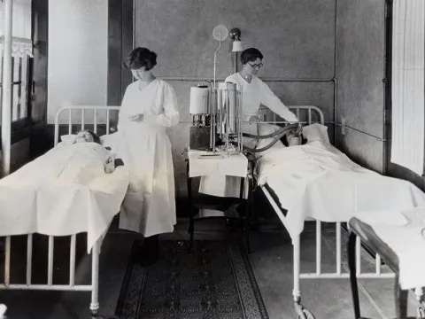 Antique photo of nurses caring for patients.