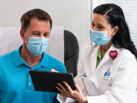 A female physician showing her patient something on the tablet