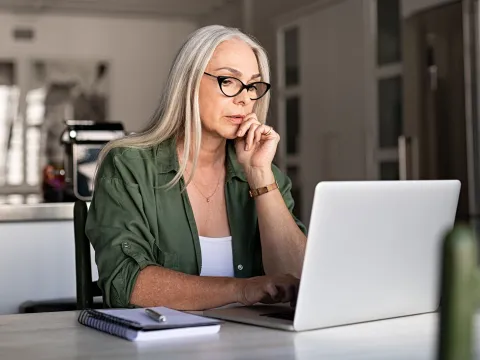 A woman in her office and on the laptop