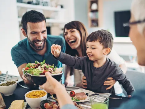  A Family Gathers Around The Kitchen Table To Enjoy Some Healthy Foods.
