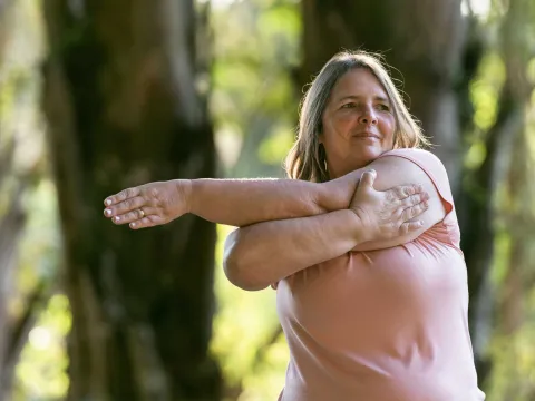 A woman stretching her arms outdoors