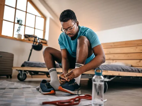 A young man tying his shoes