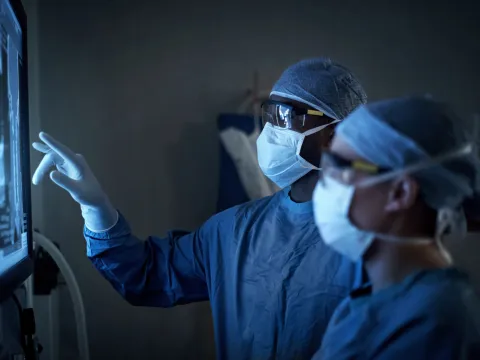 A Pair of Surgeons Review an X-Ray as they Prepare for Surgery