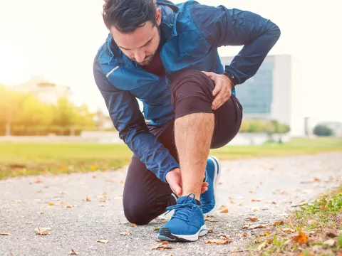 A Jogger Rubs His Ankle While Taking a Break