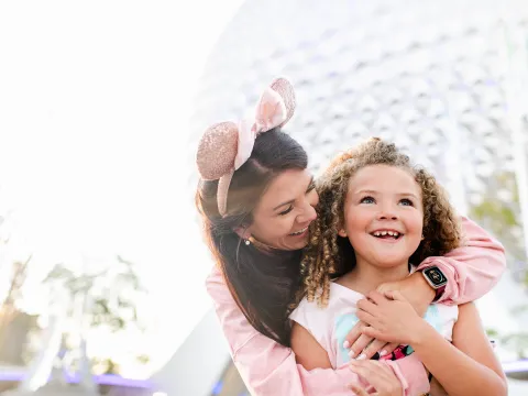 Mother and little girl standing in front of Spaceship Earth at Epcot.