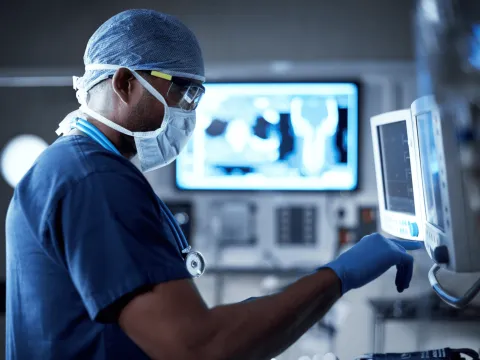 A Surgeon Reviews Monitors While in a Procedure.