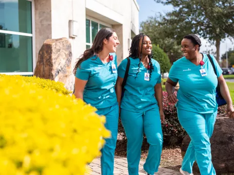 3 nurses walking outside a hospital