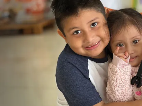 a boy hugging his sister