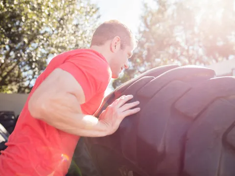 Man Pushing a Tire 
