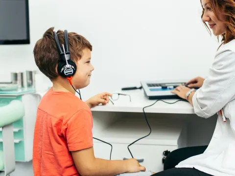 A boy getting a hearing test from a doctor.