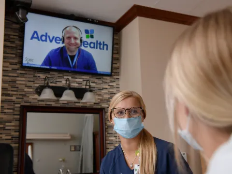 A virtual nurse comes on the television in a patient's room at AdventHealth Deland.