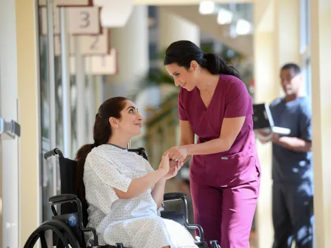 Female nurse giving a hopeful smile to female patient.