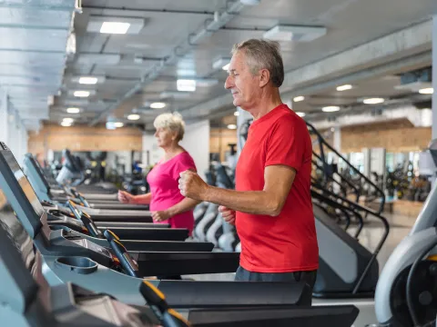 A senior man and woman doing cardiovascular rehabilitation on a treadmill