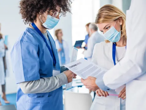 physicians wearing masks while looking at paper