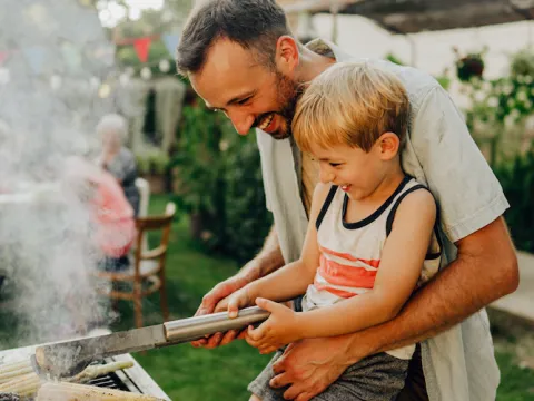 father son grill corn on the barbeque grill summer time