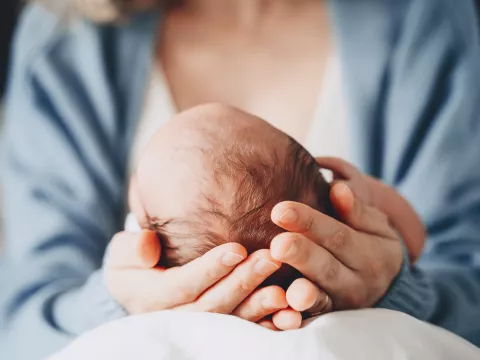 mother cradles newborn baby