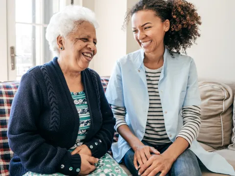 A caregiver laughs with their loved one.