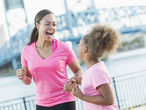 Mother and daughter holding hands for pink run