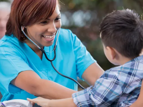 Nurse Listening to Boy's Heartbeat