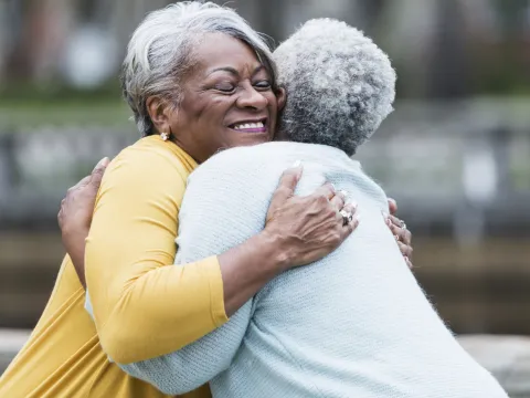 Two lifelong friends hugging.