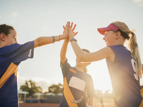 Young athletes high five after a good practice.