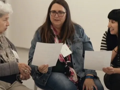 women seating while looking at papers