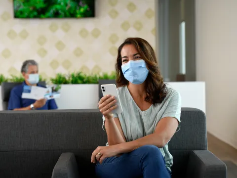 Woman using her phone while in the AdventHealth Partin Settlement Health Park lobby.