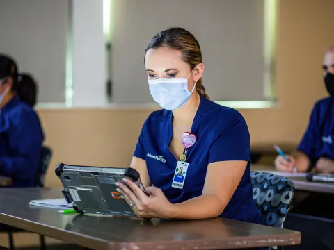 A medical employee engaged on a hospital tablet during a training class