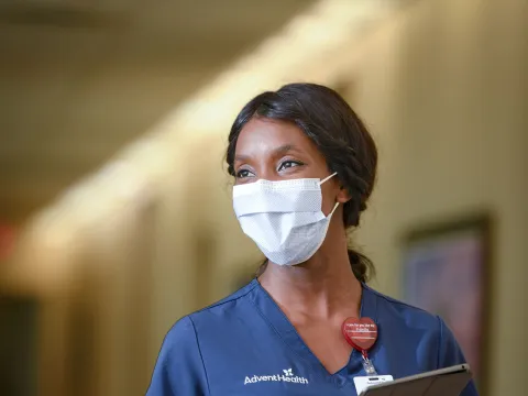 An AdventHealth nurse walking down the hallway with her tablet