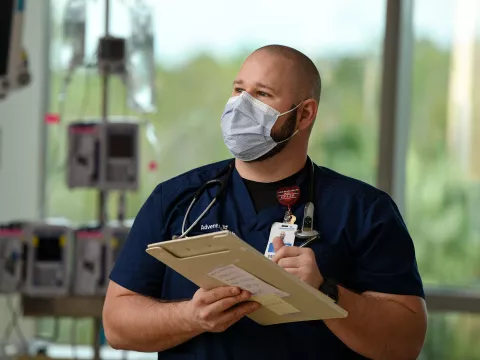 AdventHealth nurse writing on his clipboard