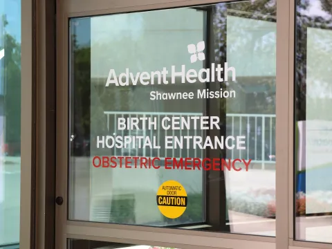 Glass door with AdventHealth Shawnee Mission logo and the words Birth Center Hospital Entrance Obstetric Emergency