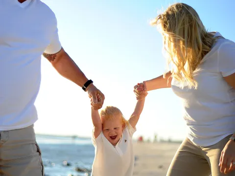 A couple with their child at the beach.