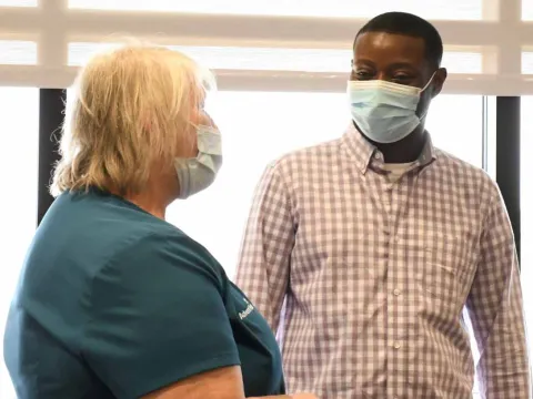 Becky Bringhurst and Desmond Yeboah visit about his recovery process. 