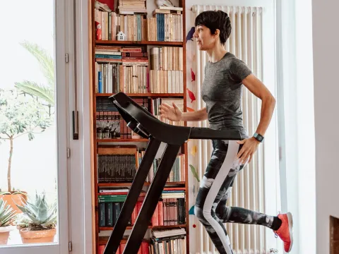 Woman running on a treadmill indoors.