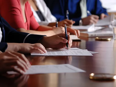 people writing notes in boardroom