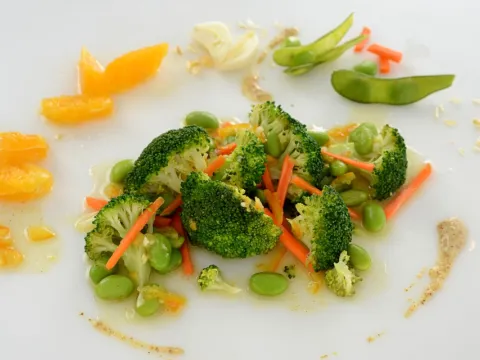 A dish comprised of broccoli, edamame, carrots, and other various ingredients