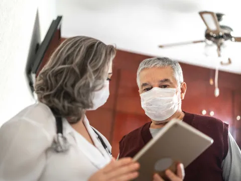 Mature female doctor talking to a male patient