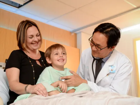 Photo of Doctor checking on pediatric patient and mom