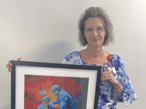 Claudia Colache Klein holding one of her art pieces