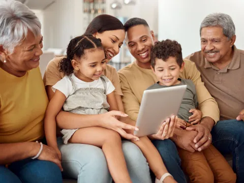 Hispanic Latino family on couch looking at iPad together 