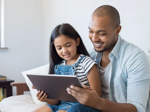 Dad and daughter reading tablet