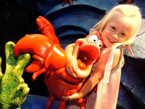 Girl hugging Sebastian the Crab at AdventHealth for Children